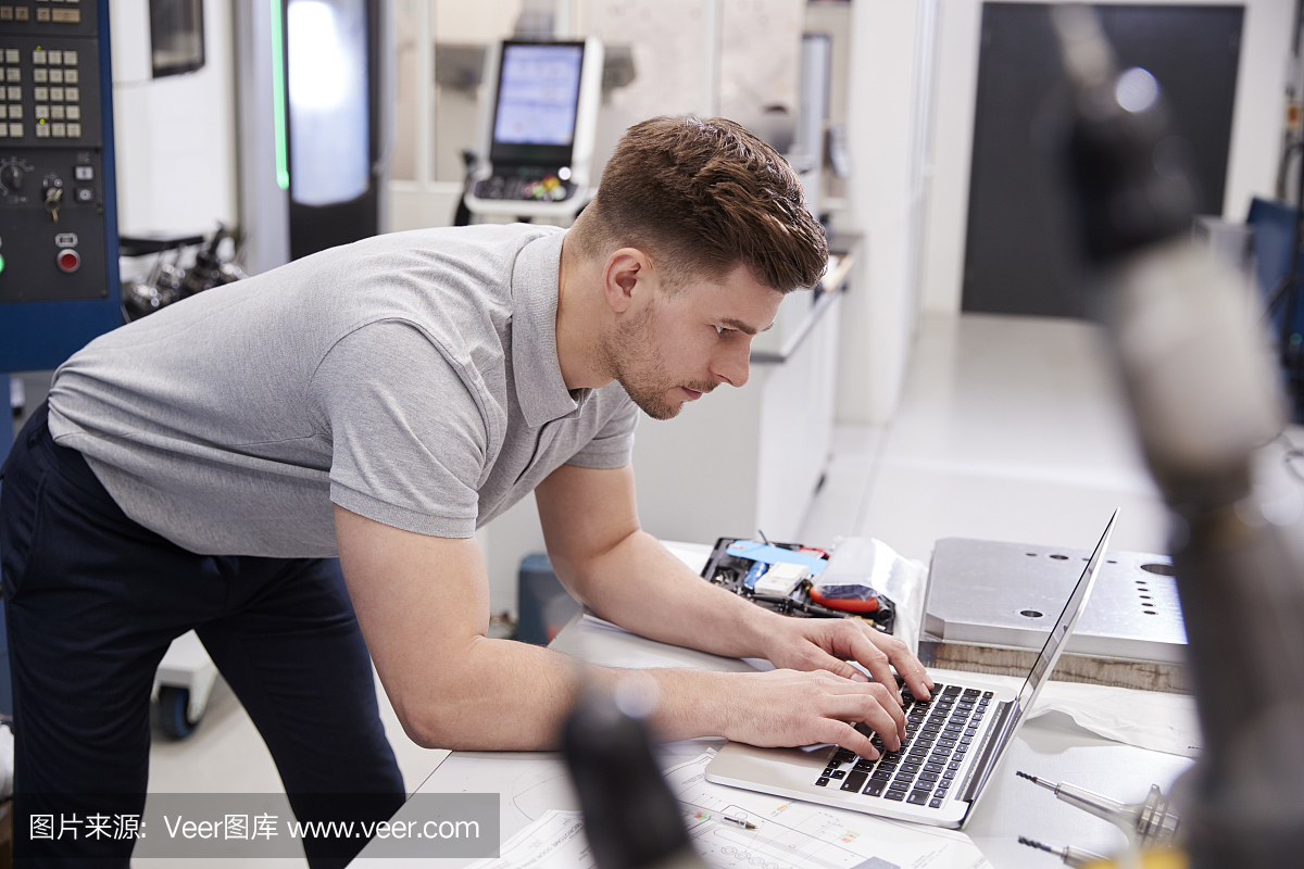 男性工程师在笔记本电脑上使用CAD编程软件
